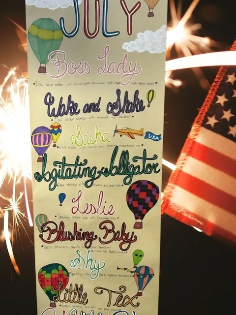 Hand-drawn specialty flavor board with hot air balloons listing flavors like Boss Lady, Wake and Shake, and Sasha